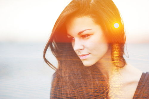 Frau mit braunen Haaren, Sonne scheint durch ihre Silhouette